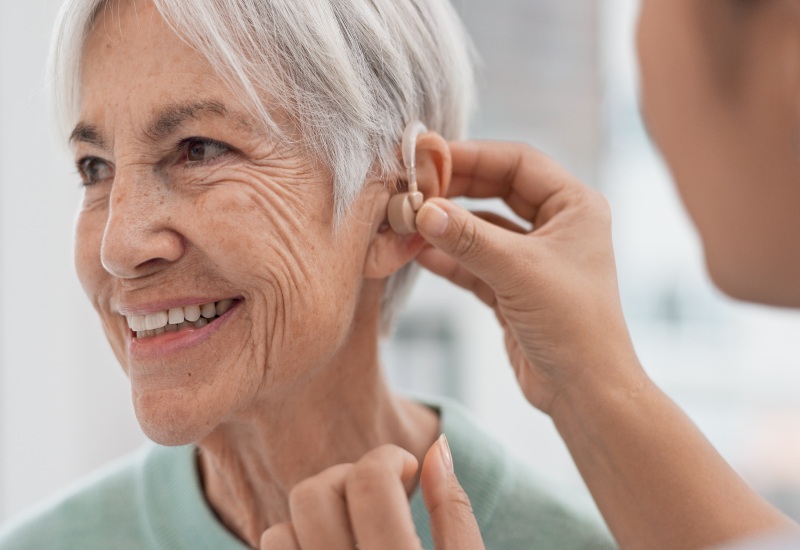 Castle Rock Ear Associates Consulting Doctor Providing Hearing Aid to a Patient in Castle Rock, CO