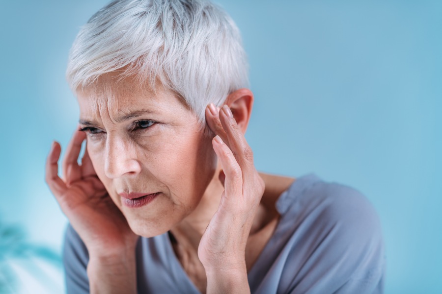 Close-Up of Individual Holding Ears to Relieve Altitude Pressure in Ears